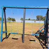 A two-seater swing set made of metal, painted in blue and green, standing on a grassy field.