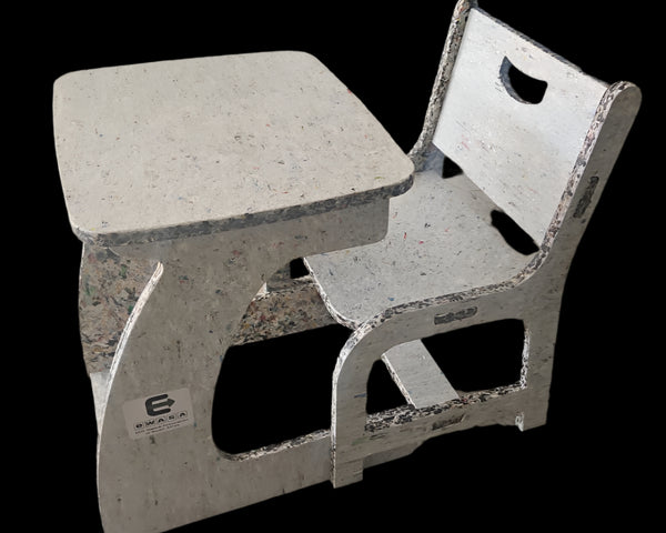 Concrete table and chair set on a concrete floor with a colorful wall in the background.